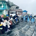Grupo de personas realizando una sesión de coaching, en el exterior de una casa típica del Himalaya