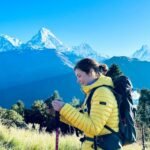 Un aventurero descansando y el fondo de la imagen se observa una parte de las cimas del Himalaya nevadas