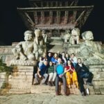 Grupo de aventura sentados a los pies de un monumento religioso típico del Himalaya.