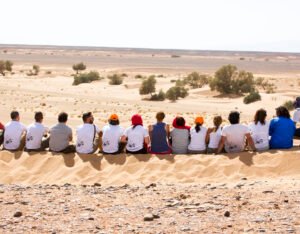 Se ve un grupo de gente compartiendo una aventura en el desierto del Sahara