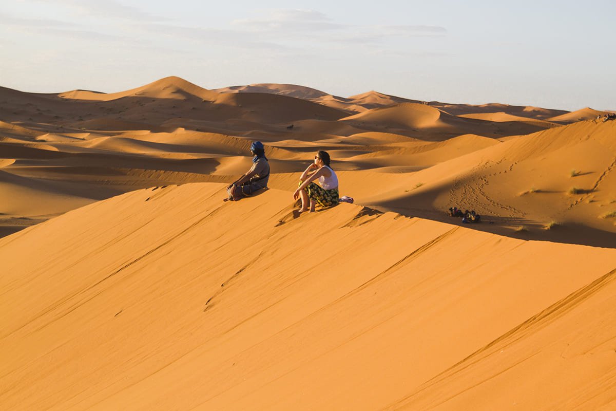 Viaja al Sahara desde Valencia. Pareja descansando en las dunas.